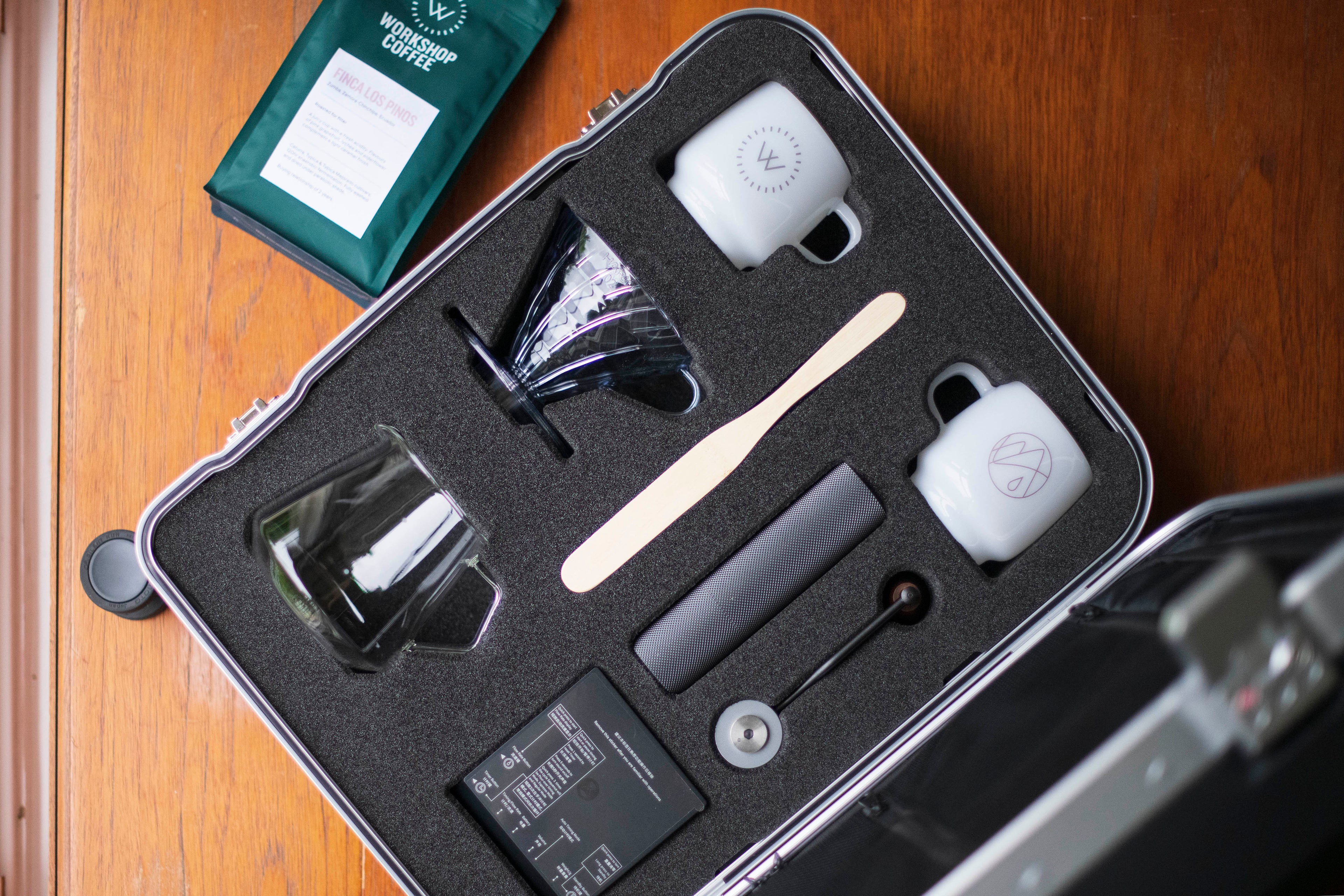 Open luxury suitcase with laser cut coffee accessories compartment with Workshop Coffee filter bag